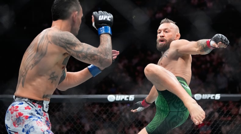 Conor McGregor, right, jumps into the air for a kick as he fights Max Holloway in a welterweight fight at the UFC 329 mixed martial arts event Saturday, July 11, 2026, in Las Vegas. (AP Photo/John Locher)