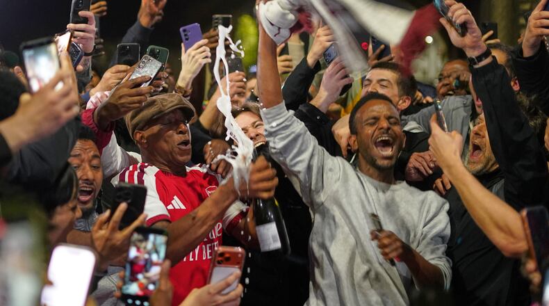 Former Arsenal player Ian Wright celebrates with Arsenal supporters at the Arsenal stadium after Arsenal's soccer team won the Premier League title in London, Tuesday, May 19, 2026.(AP Photo/Alberto Pezzali)
