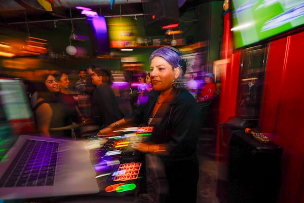 DJ La Superiorrr of La Choloteca plays Latin music during the Bad Bunny Super Bowl halftime watch party and fundraiser for Casa Alterna at Thinking Man Tavern in Decatur on Sunday, Feb. 8, 2026. (Miguel Martinez/AJC)