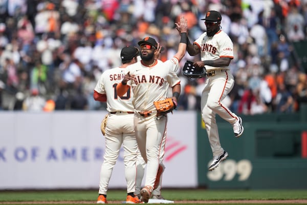 San Francisco Giants' Heliot Ramos, foreground, celebrates with Casey Schmitt, left, and Daniel Johnson after a baseball game against the Atlanta Braves in San Francisco, Sunday, June 8, 2025. (AP Photo/Jeff Chiu)