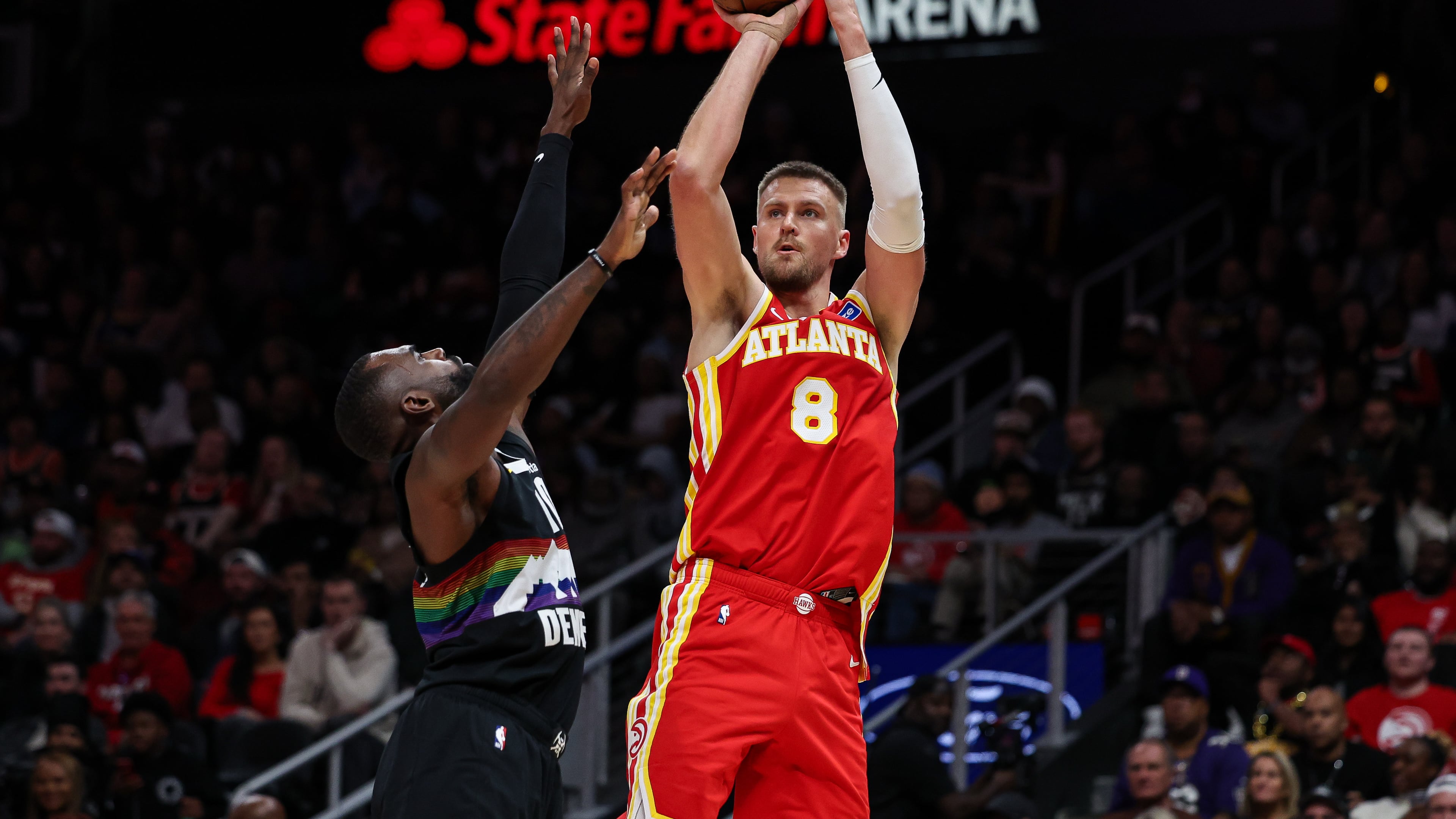 Atlanta Hawks center Kristaps Porzingis (8) attempts to shoot against Denver Nuggets guard Tim Hardaway Jr., left, during the second half of an NBA basketball game, Friday, Dec. 5, 2025, in Atlanta. (AP Photo/Colin Hubbard)