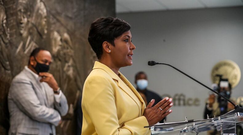 May 7, 2021 Atlanta:  Atlanta Mayor Keisha Lance-Bottoms held a press conference Friday, May 7, 2021 at Atlanta City Hall speaking about her decision not to run for a second term as her husband Derek (left) looks on. In her first public appearance since announcing her decision to supporters Thursday night, Bottoms said her decision was guided by faith. “In the same way that it was very clear to me almost five years ago that I should run for mayor of Atlanta, it is abundantly clear to me today that it is time to pass the baton on to someone else,” Bottoms said at an emotional news conference at City Hall. She added that “the last three years have not been at all what I would have scripted for our city,” referencing a crippling cyber attack, a widening federal corruption investigation into the previous administration, the COVID-19 pandemic and civil unrest last year. Bottoms said she doesn’t know what’s next for her; she denied rumors that she or her husband Derek have taken jobs for Walgreens out of state. “I can’t get Derek to move two miles off Cascade Road,” she said. Bottoms, who was seen as a strong incumbent candidate despite a spike in violent crime, told friends and supporters Thursday evening she won’t seek a second term. She released a video and statement online a few hours later elaborating on her decision and reflecting on her time in office. “This is not something I woke up and decided yesterday,” Bottoms said Friday. “This is something I’ve been thinking about for a very long time.” (John Spink / John.Spink@ajc.com)