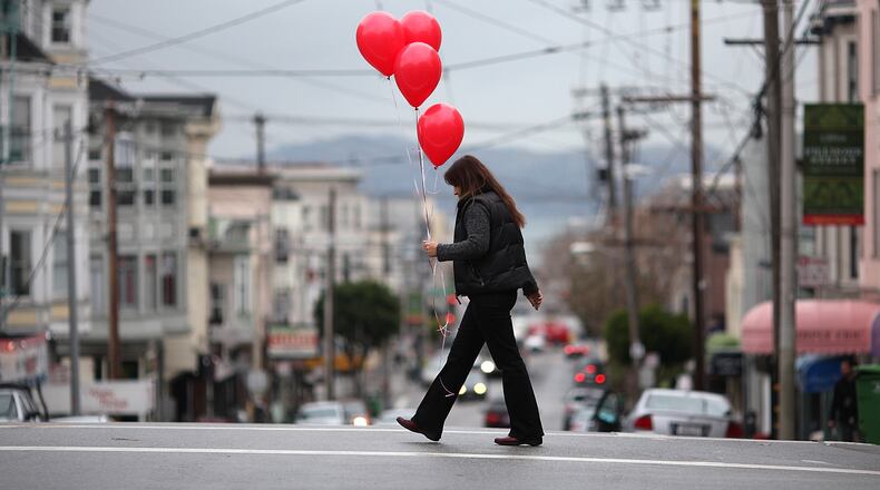 SAN FRANCISCO, CA - FEBRUARY 14: A woman carries a bunch of ballons as she walks down Union Street on Valentine's Day on February 14, 2011 in San Francisco, California. Valentine's Day is actually a Catholic church sanctioned holiday, as Pope Gelasius deemed February 14, St. Valentine's Day, near 498 A.D. (Photo by Justin Sullivan/Getty Images)