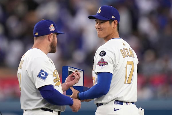 Los Angeles Dodgers' Max Muncy, left shows his ring to Shohei Ohtani during a World Series Champion ring ceremony prior to a baseball game against the Detroit Tigers, Friday, March 28, 2025, in Los Angeles. (AP Photo/Mark J. Terrill)