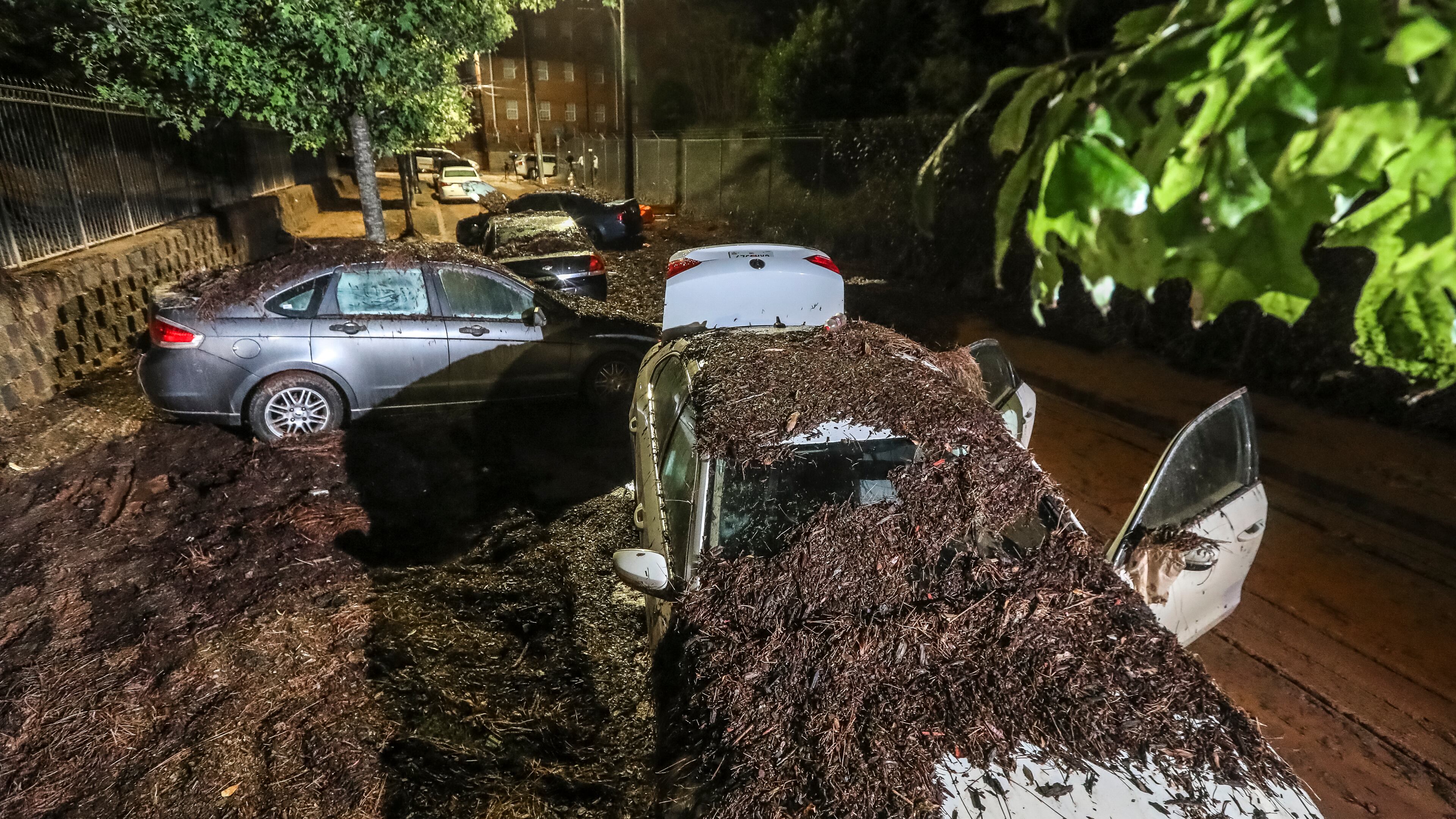 Along Parsons Street near Lawshe Street through Clark Atlanta University, so much mud was left behind it looked like a dirt road. Flooded cars remained after the water receded in 2023. (File/AJC)
