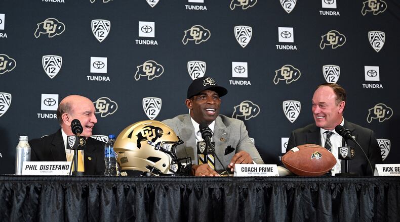 Deion Sanders, Colorado's new head football coach, flanked by Colorado Chancellor Phil DiStefano, left, and athletic director Rick George, right, takes questions in a packed audience in the Arrow Touchdown Club during a press conference on Dec. 4, 2022 in Boulder, Colorado. (Helen H. Richardson/The Denver Post/TNS)