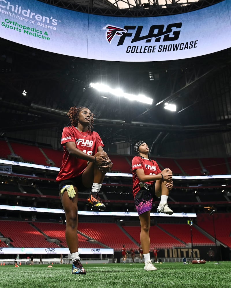 McEachern athletes Saniyah Dickens (left) and Alexa Mays warm up during the 5th annual Girls Flag Football Showcase. (Daniel Varnado for the AJC)