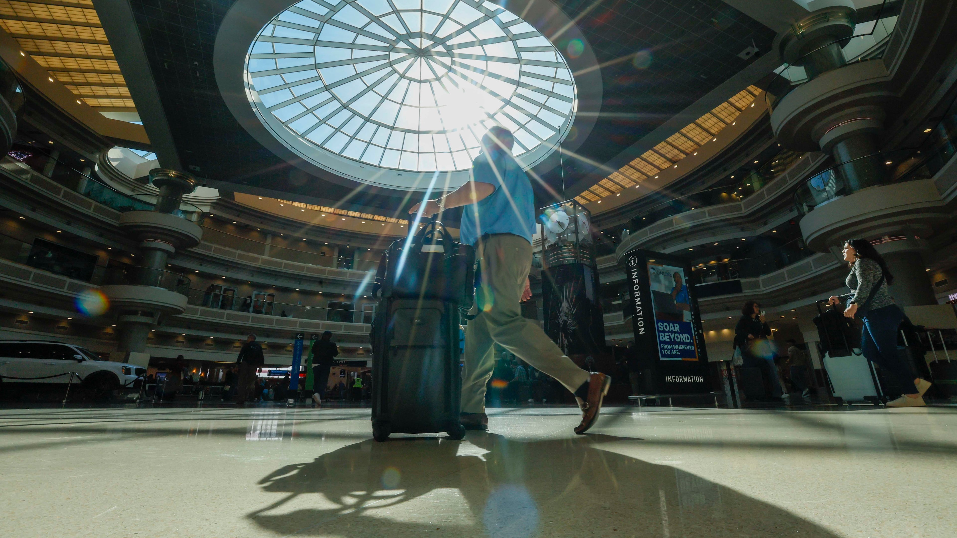 A traveler walks through the atrium at Hartsfield-Jackson Atlanta International Airport Thursday, Nov. 6, 2025. Atlanta is among the airports where the FAA has reduced flights due to the government shutdown and a shortage of air traffic controllers. (Miguel Martinez/AJC)