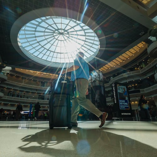 A traveler walks through the atrium at Hartsfield-Jackson Atlanta International Airport Thursday, Nov. 6, 2025. Atlanta is among the airports where the FAA has reduced flights due to the government shutdown and a shortage of air traffic controllers. (Miguel Martinez/AJC)