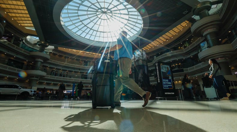 A traveler walks through the atrium at Hartsfield-Jackson Atlanta International Airport Thursday, Nov. 6, 2025. Atlanta is among the airports where the FAA has reduced flights due to the government shutdown and a shortage of air traffic controllers. (Miguel Martinez/AJC)