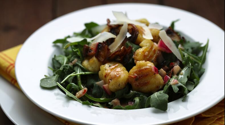 Potato gnocchi are browned in a skillet after boiling, then tossed with a simple vinaigrette and garnished with arugula, sauteed mushrooms and shaved Parmesan. (Mark Graham/food styling) (E. Jason Wambsgans/Chicago Tribune/TNS)