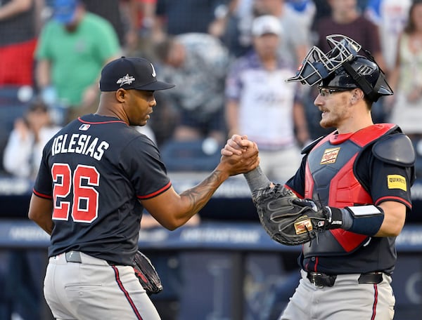 Atlanta Braves pitcher Raisel Iglesias (26) and catcher Sean Murphy, right, celebrate after their win over the Tampa Bay Rays in a baseball game, Saturday, April 12, 2025, in Tampa, Fla. (AP Photo/Jason Behnken)