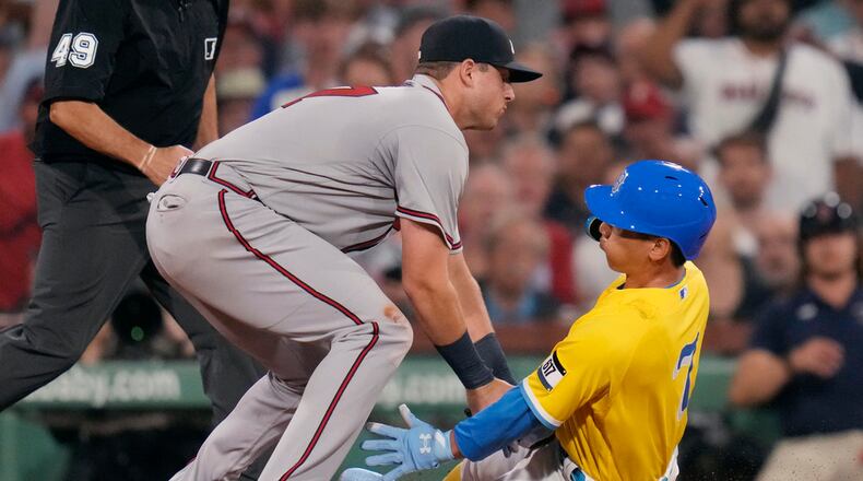 Atlanta Braves third baseman Austin Riley, left, tags out Boston Red Sox's Masataka Yoshida for the third out of a triple play during the third inning of a baseball game at Fenway Park, Tuesday, July 25, 2023, in Boston. (AP Photo/Charles Krupa)