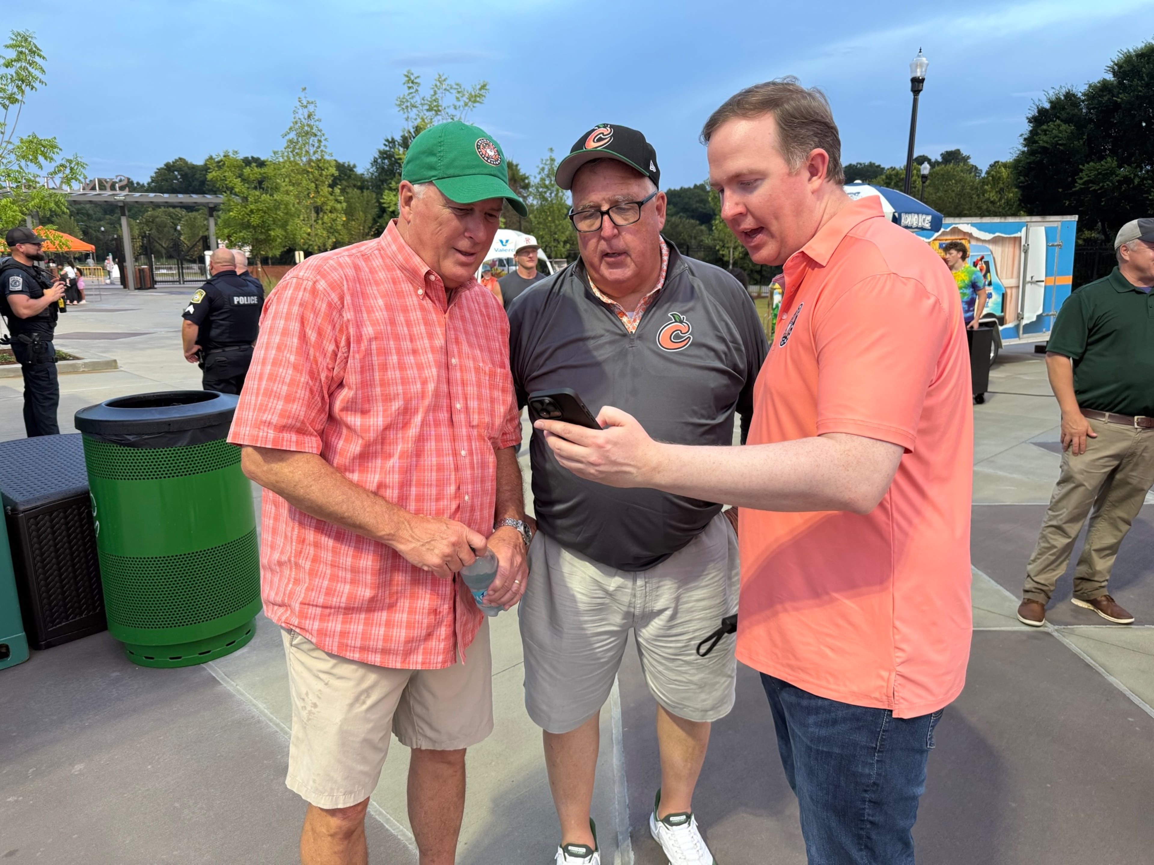 Columbus Mayor Skip Henderson (from left), veteran reporter Chuck Williams and U.S. Rep. Brian Jack chat about the Clingstones' record at Synovus Park on Friday. (Greg Bluestein/AJC)