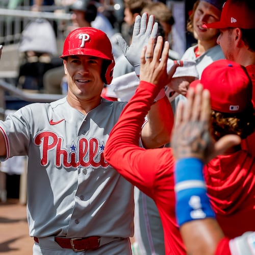 Philadelphia Phillies' J.T. Realmuto is greeted in the dugout after hitting a two-run home run against the Atlanta Braves during the second inning of a baseball game, Sunday, Sept. 13, 2026, in Atlanta. (AP Photo/Erik S. Lesser)
