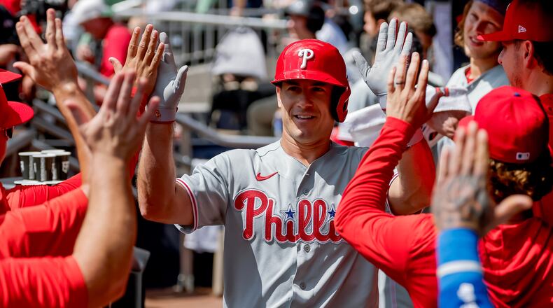 Philadelphia Phillies' J.T. Realmuto is greeted in the dugout after hitting a two-run home run against the Atlanta Braves during the second inning of a baseball game, Sunday, Sept. 13, 2026, in Atlanta. (AP Photo/Erik S. Lesser)