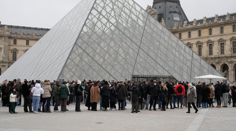 People queue outside the Louvre museum, in Paris, France, Friday, Feb. 13, 2026. (AP Photo/Michel Euler)