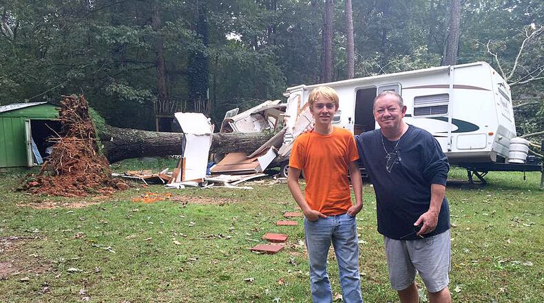 Mac Hubbard, right, pulled his 18-year-old son, Jonn, out of a camper Sunday morning after a tree fell on top of it. (Photo: Channel 2 Action News)
