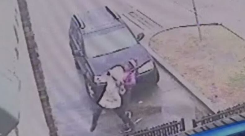 A gas station surveillance camera shows a woman fighting off another woman before three men pick up her dropped keys and drive away in her car. (Credit: Channel 2 Action News)