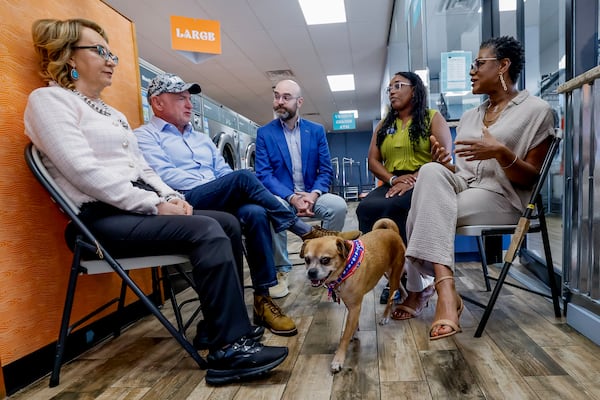 From left, Former Arizona Rep. Gabby Giffords and her husband, U.S. Sen. Mark Kelly, meet with Democratic lieutenant governor nominee Senator Josh McLaurin, Sandy Springs councilwoman Melody Kelley and business owner Sherwin Clemons, as Clemons' dog Foxxie checks out the scene during a campaign stop of Democratic Party candidates and issues at the Laundry Lounge on Wednesday, Aug. 19, 2026 in Sandy Springs. (Erik S. Lesser for the AJC)