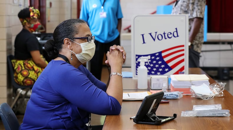 Poll manager Michelle Hairston and poll workers wait between voters during Tuesday's election runoff at Flat Shoals Elementary School in Atlanta. Curtis Compton ccompton@ajc.com