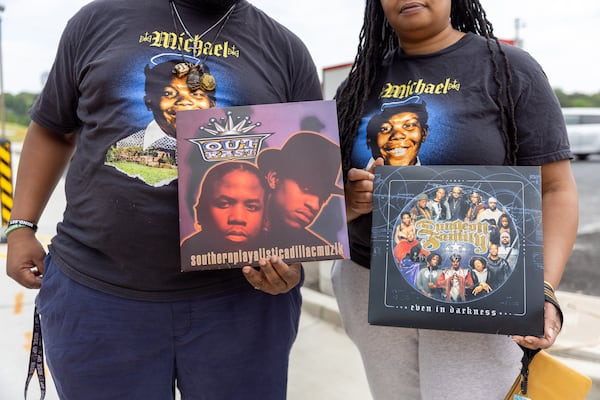 Mourners watching the funeral procession of hip-hop pioneer Rico Wade carry records at the intersection of Headland and Delowe, an East Point hip-hop landmark, on Friday, April 26, 2024. (Arvin Temkar / AJC)