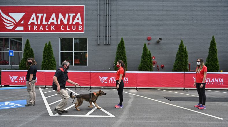 Jerry Bishop (left), director of training with the 360 K9 Group, demonstrates how his bio detection K-9 partner detects scents associated with COVID-19 during a presentation on safety measures planned for the AJC Peachtree Road Race at the Atlanta Track Club in Atlanta. (Hyosub Shin / Hyosub.Shin@ajc.com)