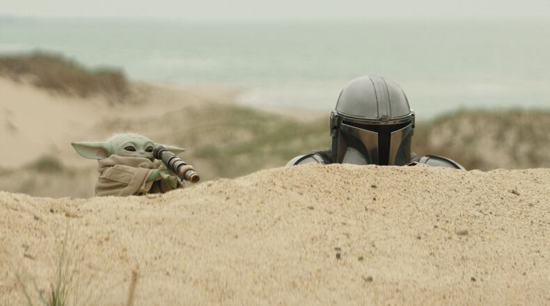 This image released by Disney shows The Mandalorian, portrayed by Pedro Pascal, right, and Grogu in a scene from Lucasfilm's "Star Wars: The Mandalorian and Grogu." (Lucasfilm Ltd. - Disney via AP)