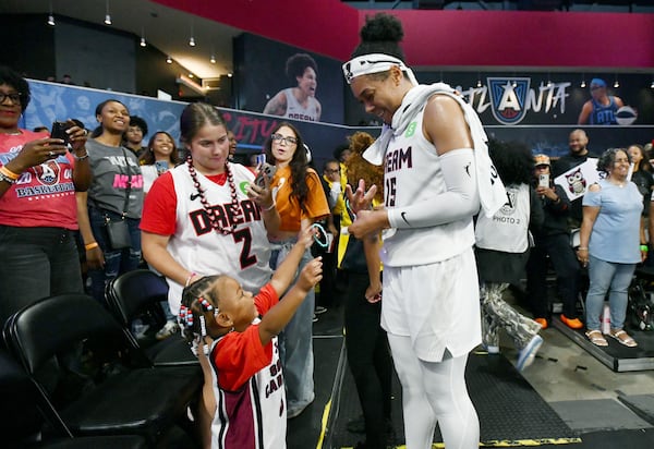Dream guard Allisha Gray is greeted by a young fan inside Gateway Center Arena on May 24 in Atlanta. Gray struggled in the first half of Friday's game, finishing with 7 points on 2-of-6 shooting from the floor and three rebounds and two assists. (Hyosub Shin/AJC)
