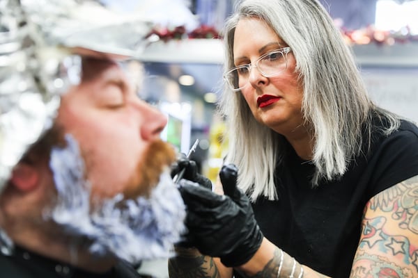 Stylist Shannon Woodard applies hair dye to Jeremiah Mitchell’s beard at Three-13 Salon in Marietta, Ga., on Tuesday, November 25, 2025. Woodard is one of the stylists who preps Atlanta’s working Santas for the season and also works as an educator and manager at the salon. (Abbey Cutrer / AJC)