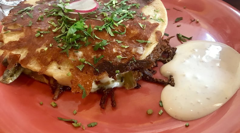 The mulita is a Mexican version of an enhanced grilled cheese sandwich. Two corn tortillas flank a mixture of rajas (strips of roasted poblano chiles), a choice of filling and chihuahua cheese, with crema on the side. LIGAYA FIGUERAS / LFIGUERAS@AJC.COM