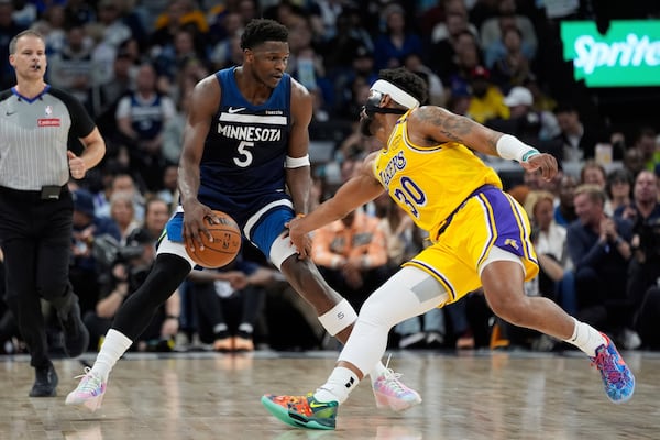 Minnesota Timberwolves guard Anthony Edwards (5) works toward the basket as Los Angeles Lakers guard Jordan Goodwin (30) defends during the first half of Game 3 of an NBA basketball first-round playoff series, Friday, April 25, 2025, in Minneapolis. (AP Photo/Abbie Parr)