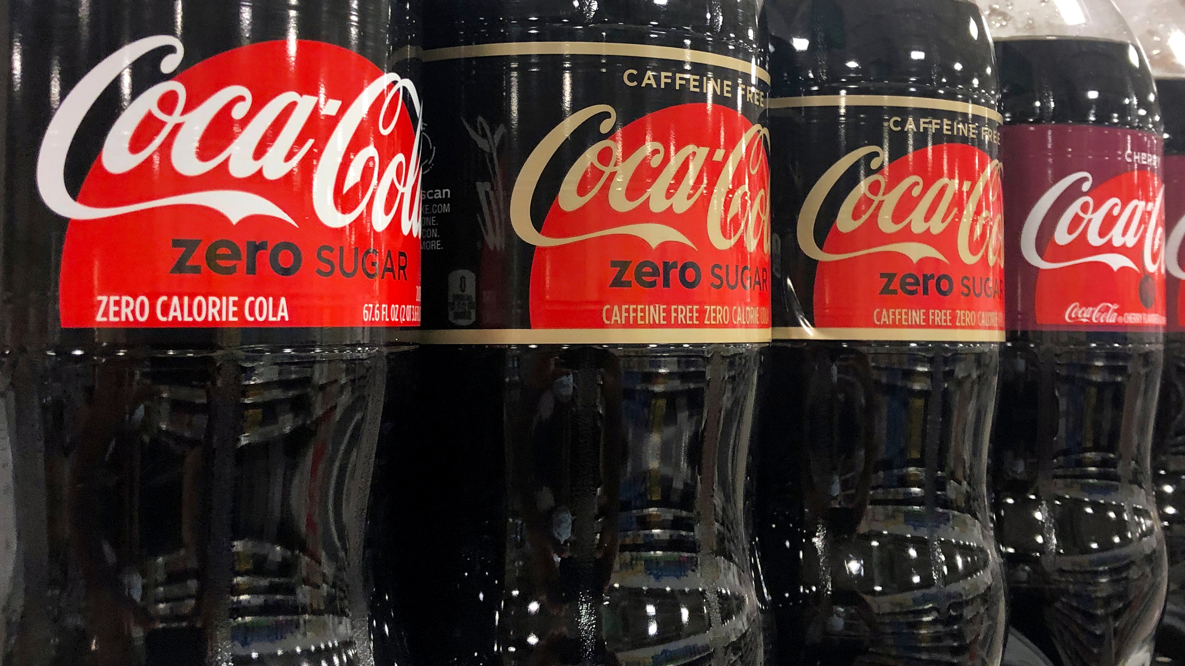 FILE - Bottles of Coca-Cola products sit on a shelf at a store in Dania Beach, Fla., Oct. 20, 2020. (AP Photo/Wilfredo Lee, File)
