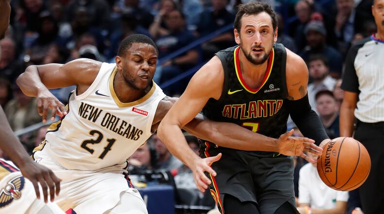 New Orleans Pelicans forward Darius Miller (21) reaches for the ball against Atlanta Hawks guard Marco Belinelli during the second half of an NBA basketball game in New Orleans, Monday, Nov. 13, 2017. The Pelicans won 106-105. (AP Photo/Tyler Kaufman)