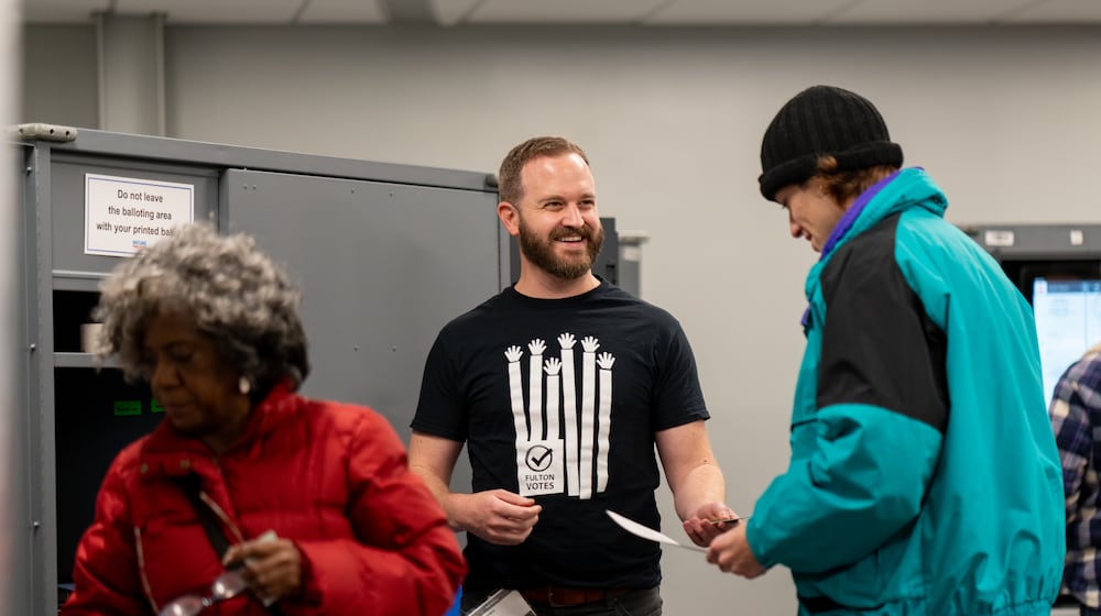 Patrick Raber (center) assists voters in casting their ballots inside the Buckhead Library voting precinct on Tuesday, Nov. 4, 2025 (Ben Hendren for the AJC)