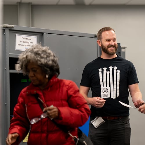 Patrick Raber (center) assists voters in casting their ballots inside the Buckhead Library voting precinct on Tuesday, Nov. 4, 2025 (Ben Hendren for the AJC)