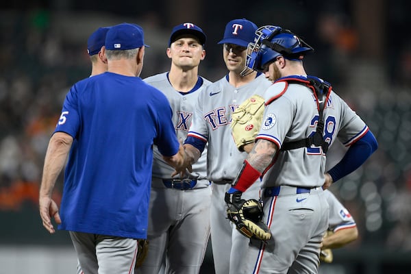 Texas Rangers starting pitcher Jacob deGrom, second from right, is pulled from the game by manager Bruce Bochy, left, during the eighth inning of a baseball game against the Baltimore Orioles, Wednesday, June 25, 2025, in Baltimore. (AP Photo/Nick Wass)
