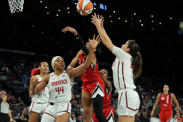From right, Washington Mystics guard Sonia Citron (22), Las Vegas Aces center A'ja Wilson (22) and Washington Mystics forward Kiki Iriafen (44) battle for the ball during the second half of a WNBA basketball game Thursday, June 26, 2025, in Las Vegas. (AP Photo/John Locher)