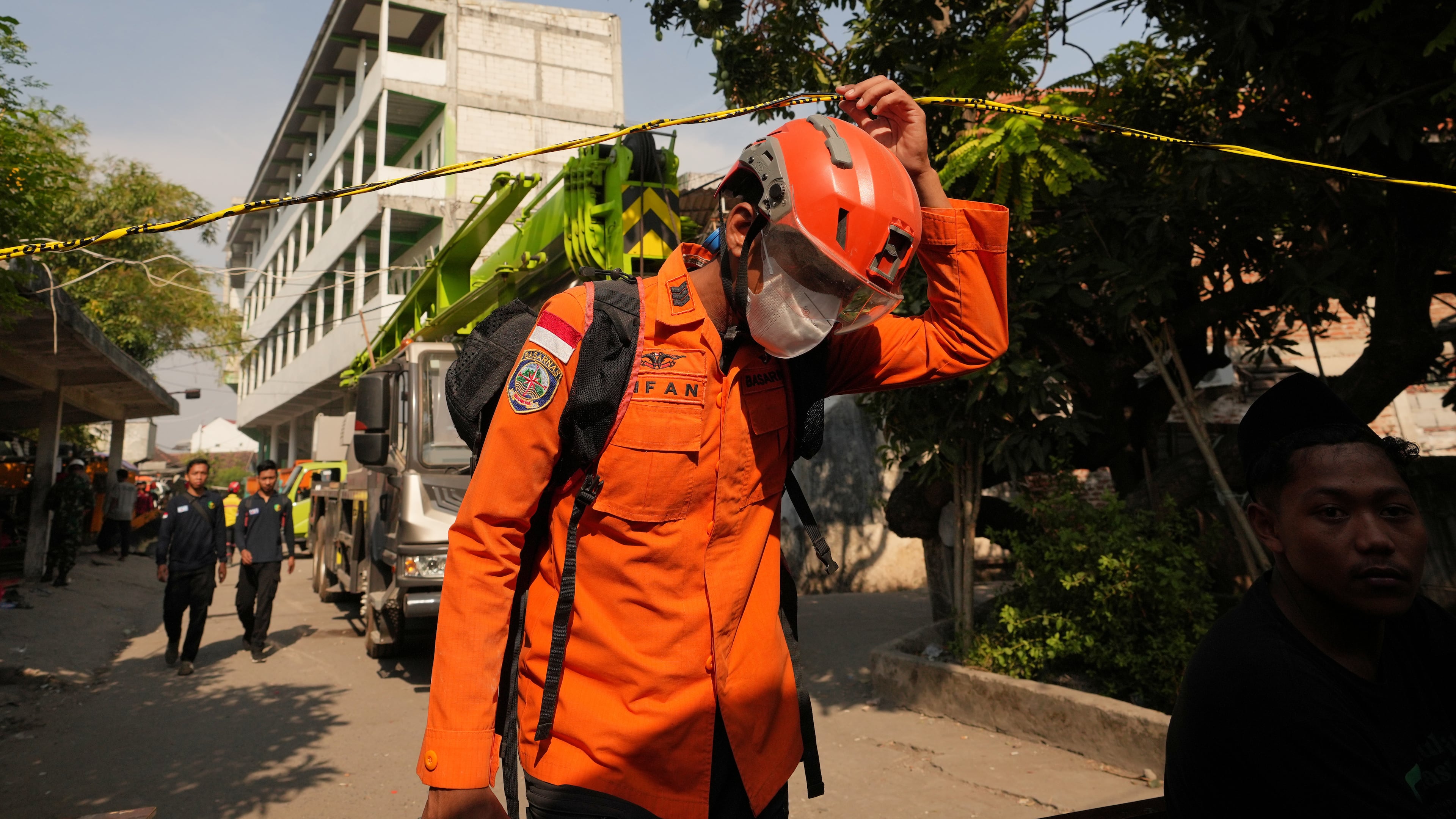 A rescuer walks near the islamic boarding school where a building collapsed in Sidoarjo, East Java, Indonesia, Saturday, Oct. 4, 2025. (AP Photo/Achmad Ibrahim)