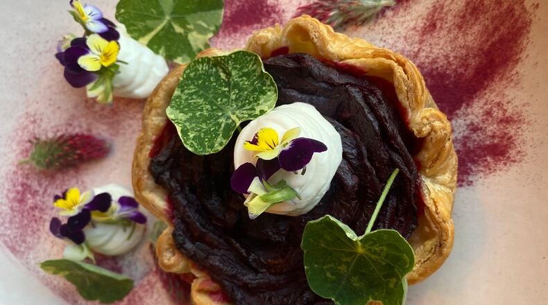 The beet root tart at Auburn Angel brings a stunning rose petal arrangement of cooked, sliced beets tucked inside a pastry shell with garnishes of goat cheese mousse, nasturtium leaves and flowers, crimson clover and beet root dust. (Ligaya Figueras/lfigueras@ajc.com)