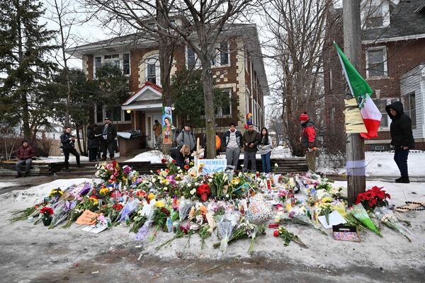 People gather around a makeshift memorial honoring Renee Good who was fatally shot by a federal law enforcement agent near the site of the shooting in Minneapolis, Thursday, Jan. 8, 2026. (Tom Baker/AP)