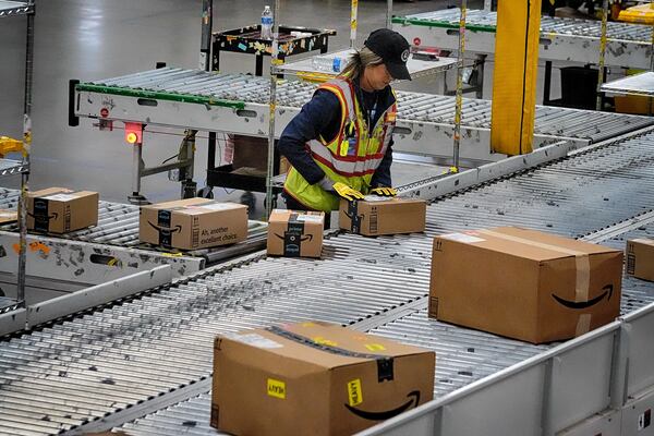 FILE - An Amazon employee puts packages on to a conveyor belt at an Amazon's DAX7 delivery station during Amazon's annual Prime Day event, July 16, 2024, in South Gate, Calif. (AP Photo/Richard Vogel, File)
