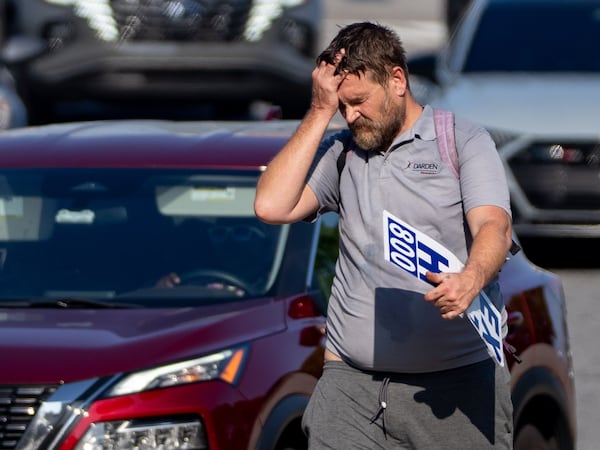 A man wipes sweat off his forehead as he walks along the median on 17th Street in Midtown as temperatures reach over 90 degrees on Tuesday, June 24, 2025. (Ben Hendren for The Atlanta Journal-Constitution)