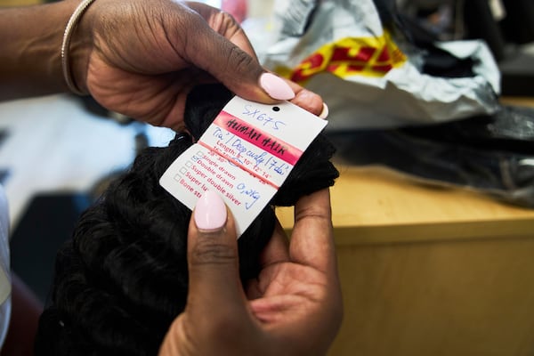 Dajiah Blackshear, a natural hair stylist who specializes in extensions, shows a bundle of human hair sourced from a vendor in China and shipped through DHL, Monday, May 5, 2025, at her salon suite in Atlanta. (AP Photo/Stephanie Scarbrough)