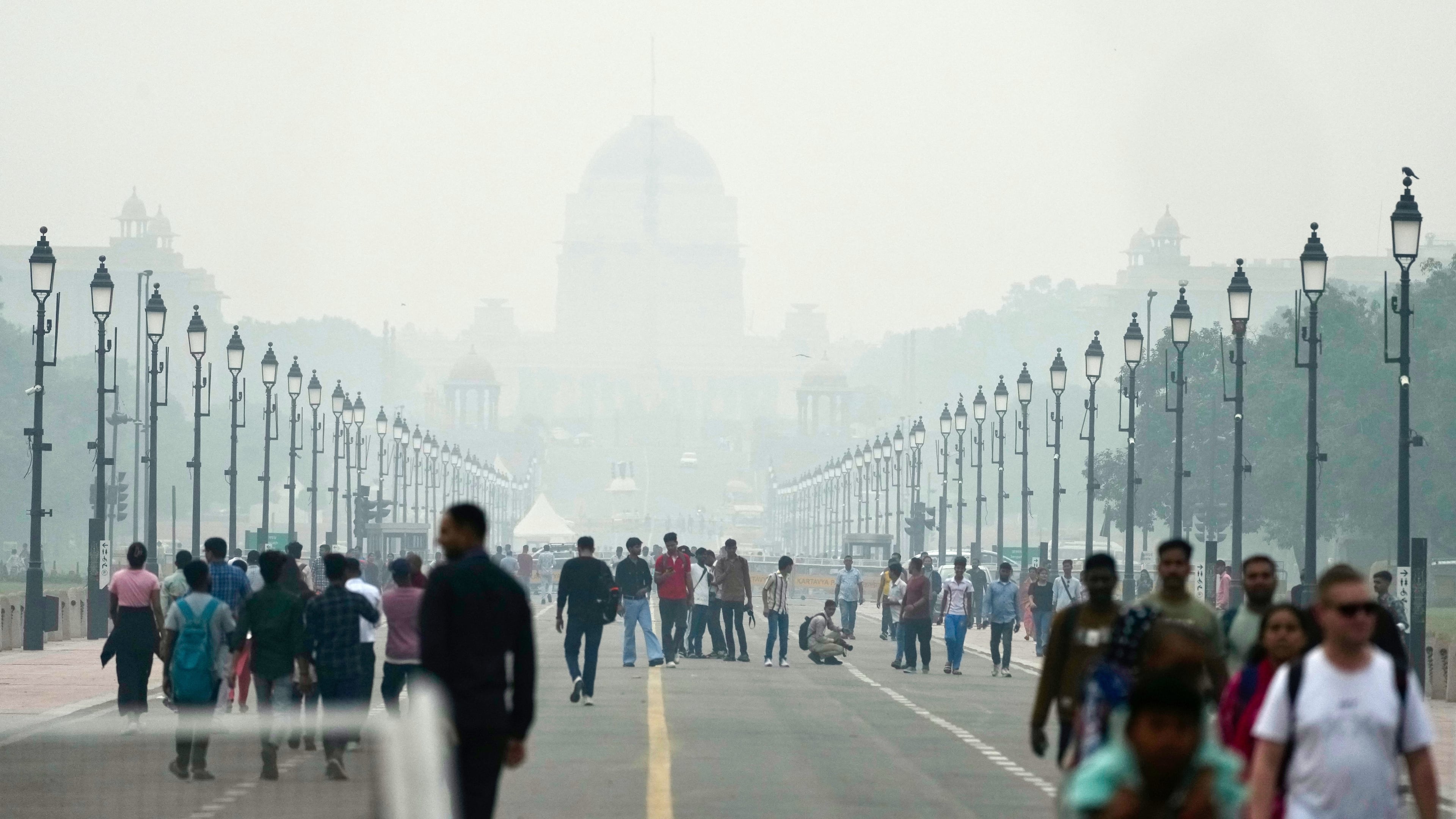 People walk on a street enveloped in smog, in New Delhi, India, Tuesday, Oct. 28, 2025. (AP Photo/Manish Swarup)