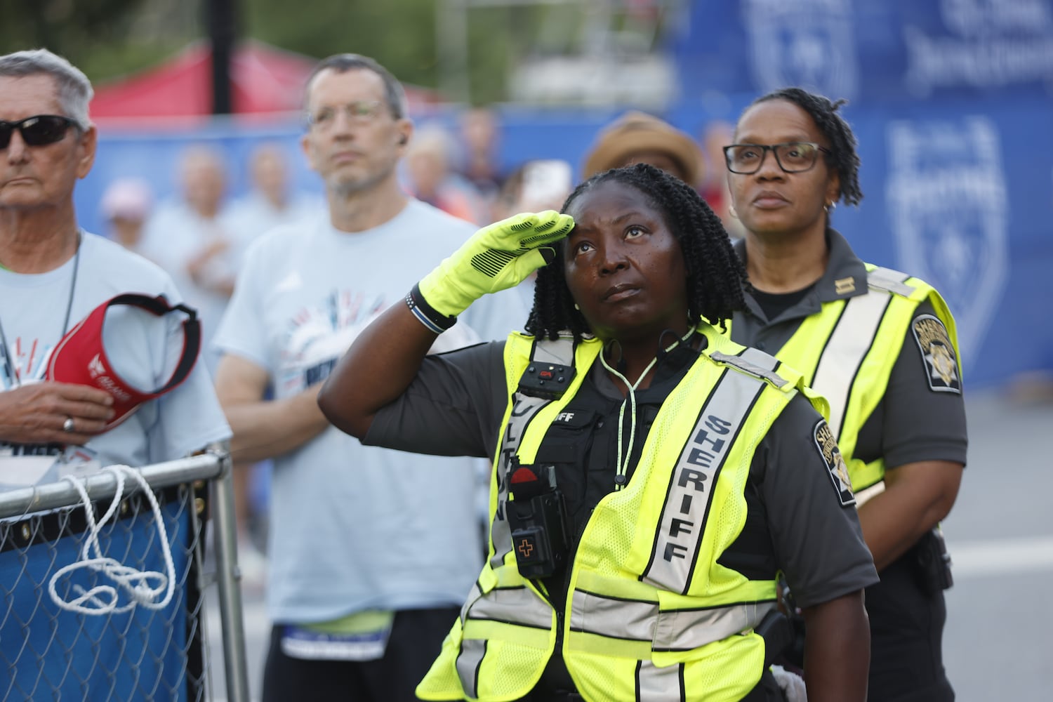 A sheriff’s deputy salutes during the national anthem at the start of the 56th running of the Atlanta Journal-Constitution Peachtree Road Race on Friday, July 4, 2025, in Atlanta. (Arvin Temkar/AJC)