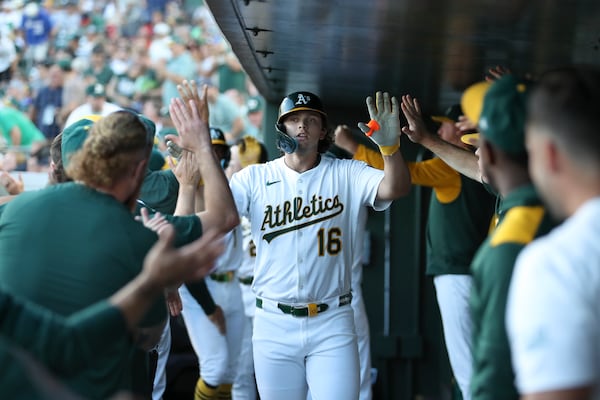 Athletics' Nick Kurtz high fives his teammates after hitting a grand slam against the Atlanta Braves during the second inning of a baseball game Tuesday, July 8, 2025, in West Sacramento, Calif. (AP Photo/Scott Marshall)