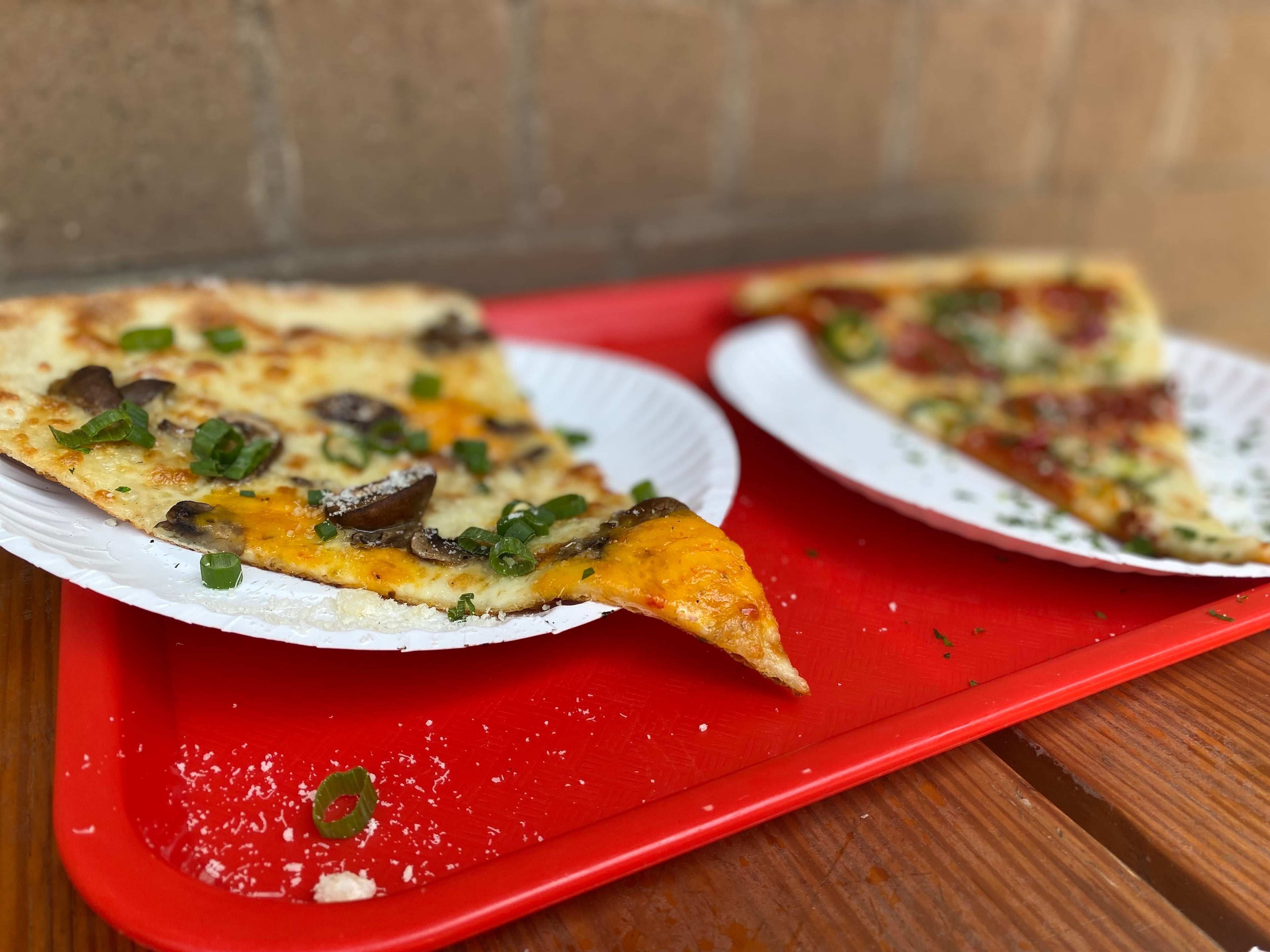 Old Fourth Ward pizzeria Glide sells slices of its massive 20-inch Brooklyn-style pies, including the Homegrown (left) featuring pimento cheese. (Ligaya Figueras/AJC)