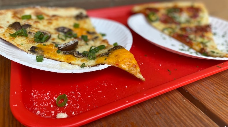 Old Fourth Ward pizzeria Glide sells slices of its massive, 20-inch Brooklyn-style pies, including the Homegrown (left) featuring pimento cheese. Ligaya Figueras/ligaya.figueras@ajc.com