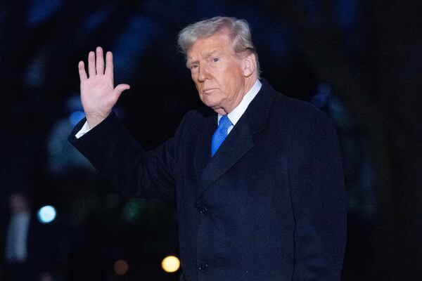 President Donald Trump waves to the news media as he walks on South Lawn of the White House on Sunday.